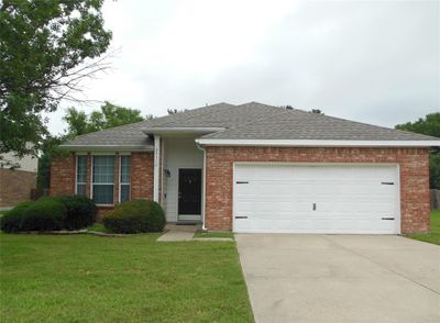 Ranch-style home with a garage and a front lawn | Image 1