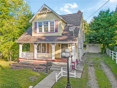 View of front of house with a front lawn, covered porch, a garage, and an outdoor structure | Image 3