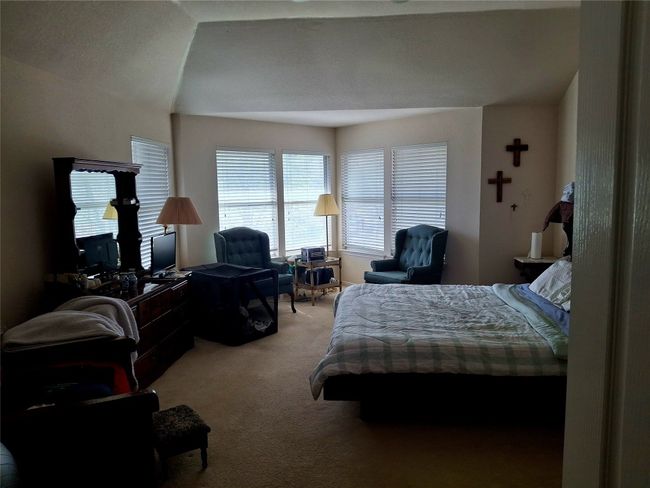 Carpeted bedroom featuring lofted ceiling with sitting area | Image 10