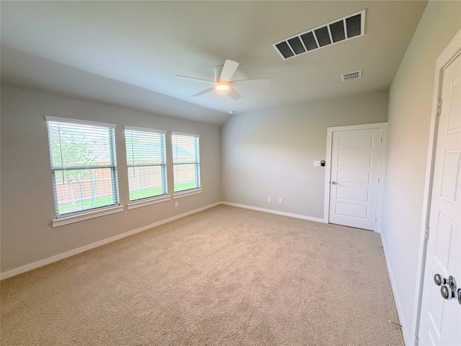 Unfurnished room with a ceiling fan, light colored carpet, baseboards, and lofted ceiling | Image 29