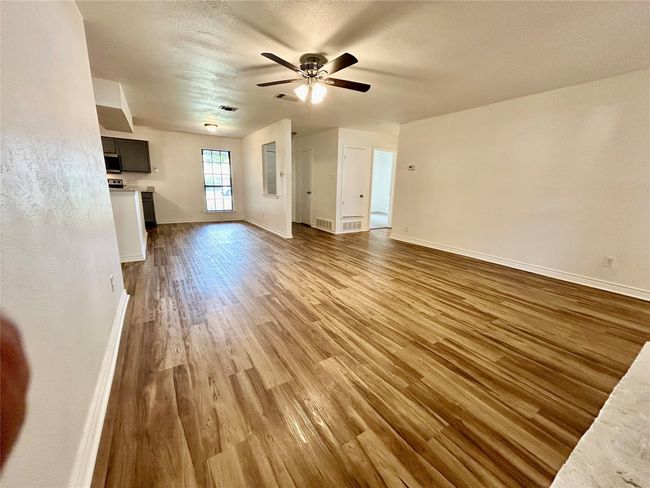 Unfurnished living room with wood finished floors, ceiling fan, and baseboards | Image 6