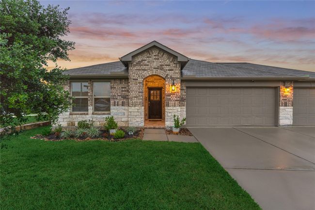 Charming brick and stone elevation and a lush green lawn greet you upon arrival. | Image 5