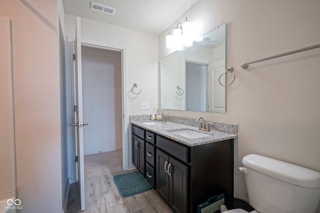 bathroom featuring toilet, a sink, double vanity, and visible vents | Image 31