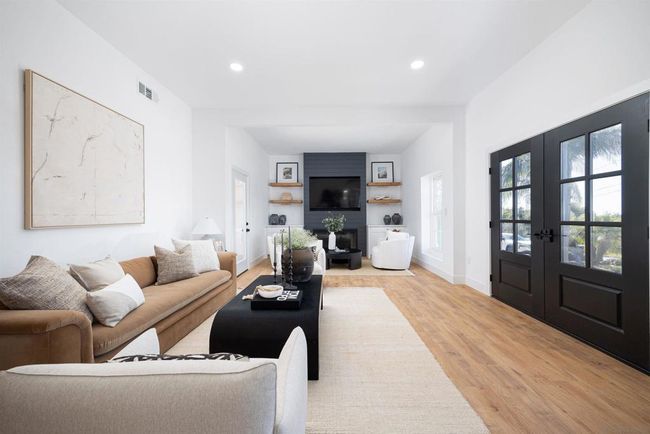 Large living room and entry area, custom fireplace with built in cabinets and floating shelves | Image 19