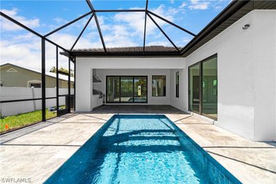 View of swimming pool with glass enclosure and a patio area | Image 1