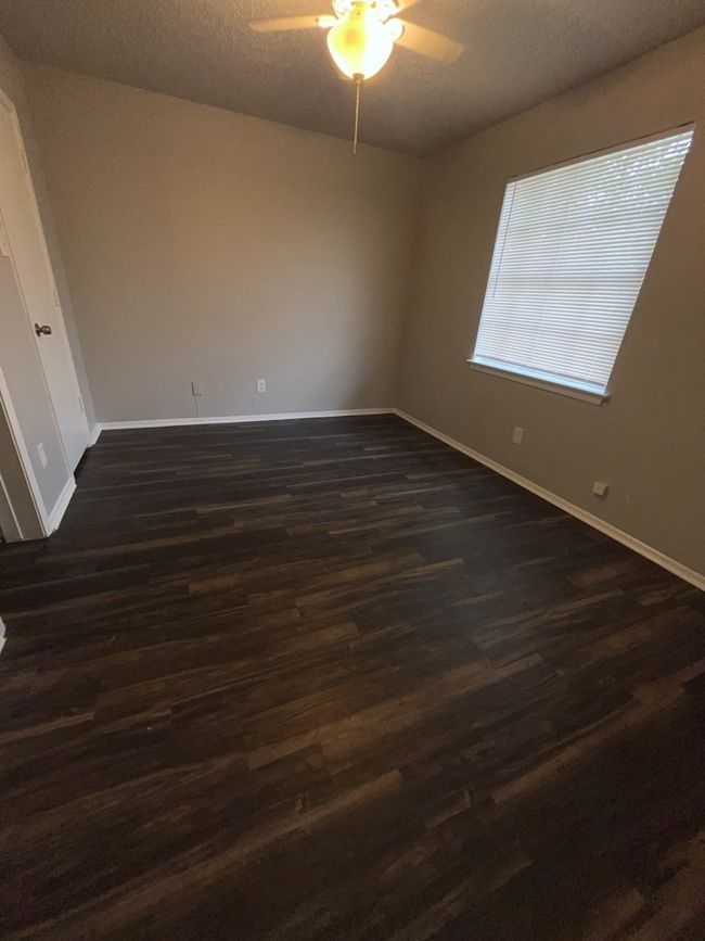 Bedoom with a ceiling fan, baseboards, dark wood-style floors, and a textured ceiling | Image 4