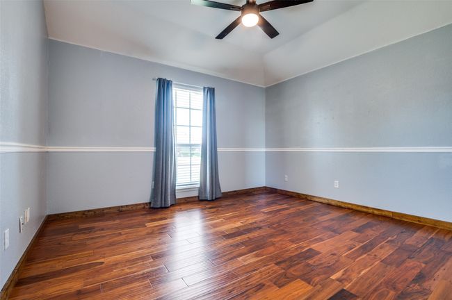 Unfurnished room with a ceiling fan, wood finished floors, and vaulted ceiling | Image 4