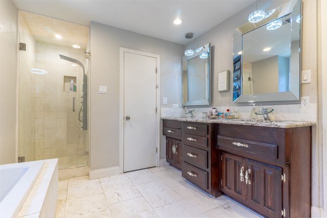 Bathroom featuring a shower stall, double vanity, a bath, baseboards, and recessed lighting | Image 17
