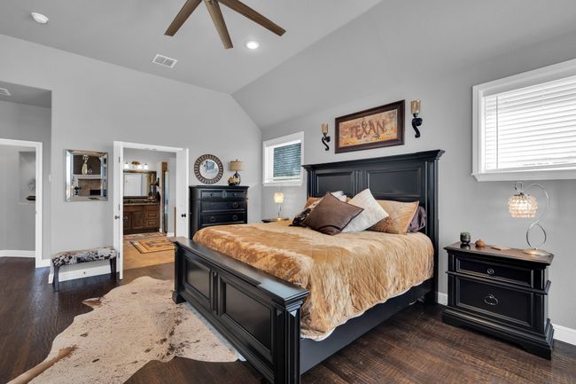 Bedroom with ceiling fan, dark wood-type flooring, ensuite bathroom, and multiple windows | Image 15