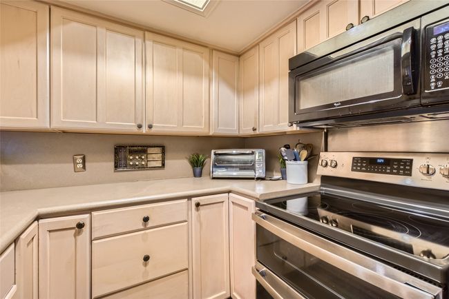Kitchen with range with two ovens, black microwave, and light countertops | Image 8
