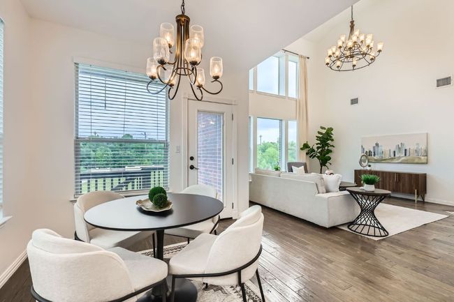 Dining room featuring a chandelier, wood finished floors, baseboards, and a high ceiling | Image 9