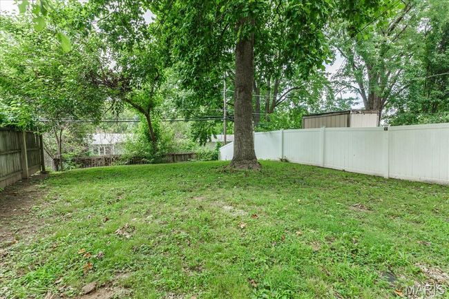 View of fenced backyard | Image 15