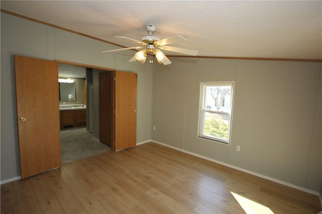 Massive 13x13 Master Bedroom Suite featuring Newer Rockwood Oak Vinyl Plank Flooring installed 2/25, Ceiling Fan Light & Majestic Double Doors opening into En Suite Full Bathroom including 2 Separate Walk-in Closets! | Image 13