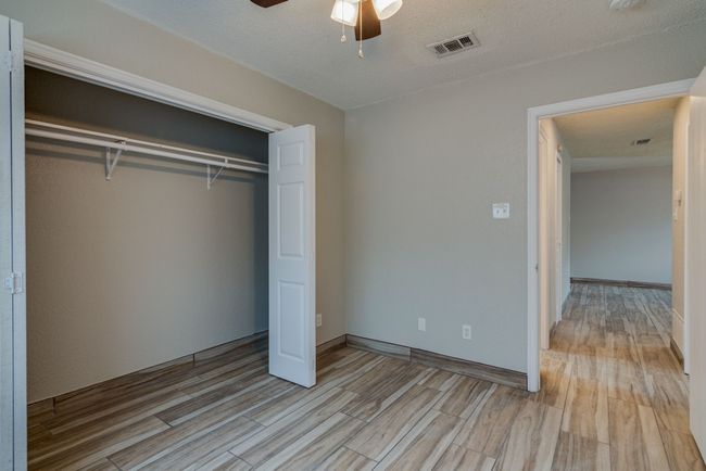 Unfurnished bedroom featuring visible vents, ceiling fan, a closet, and light wood-style flooring | Image 16