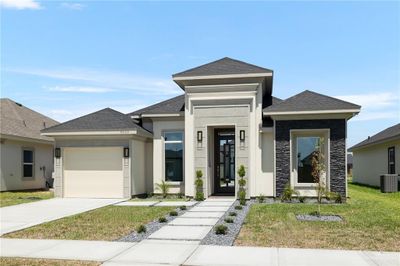 Prairie-style house with a garage, a front lawn, and cooling unit | Image 1