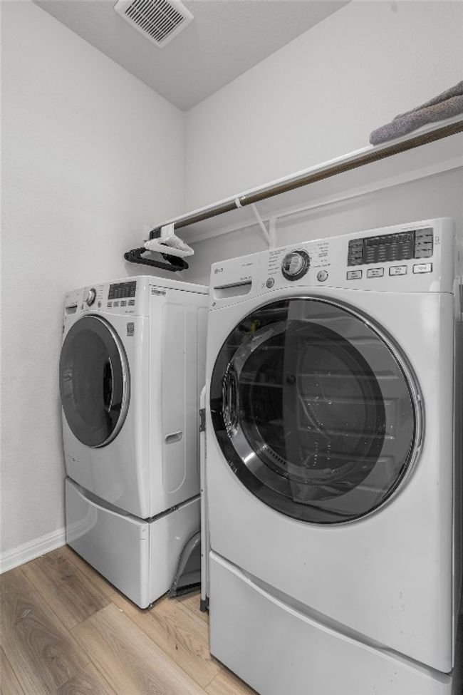 Laundry room with separate washer and dryer, light wood-style floors, and baseboards | Image 18