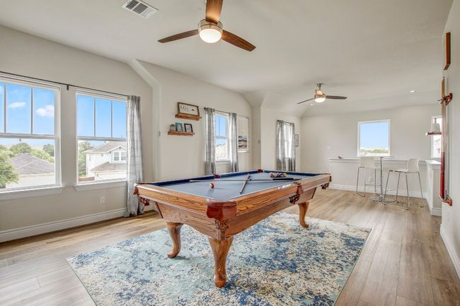 Game room with ceiling fan, billiards, and light wood-style flooring | Image 27