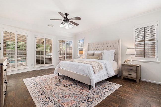 A serene primary suite should be on your list of must haves. This bedroom has neutral tones, crown molding and shutters that control the light to just how you like it, from sunny summer days, or nighttime privacy! | Image 11