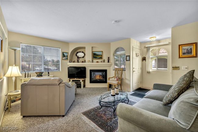 Living area featuring carpet flooring, a wealth of natural light, and a glass covered fireplace | Image 20