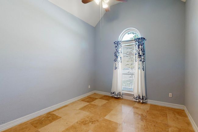 Unfurnished room with baseboards, a ceiling fan, plenty of natural light, and lofted ceiling | Image 26