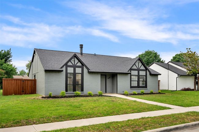 Tudor home featuring roof with shingles and brick siding | Image 4