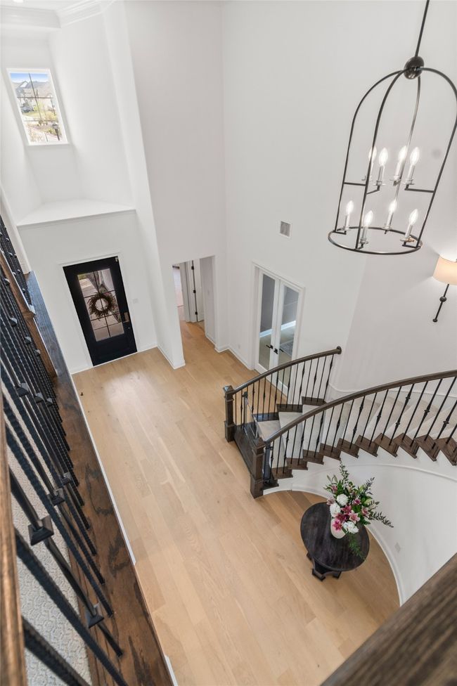 Foyer featuring stairway, a towering ceiling, wood finished floors, french doors, and a chandelier | Image 19