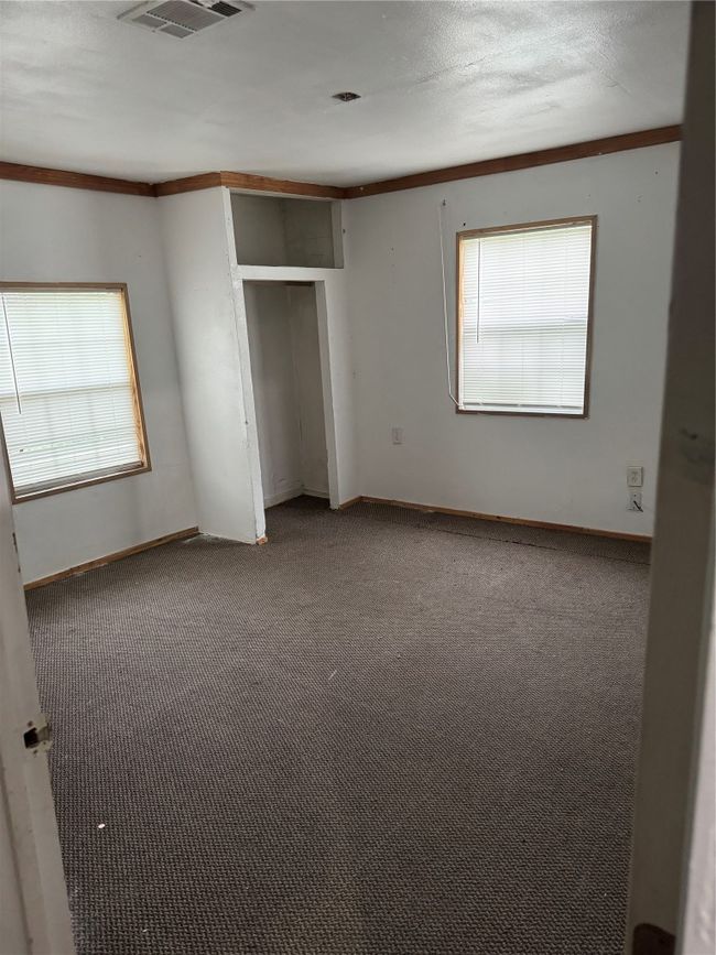 Unfurnished bedroom with baseboards, carpet flooring, multiple windows, and visible vents | Image 7