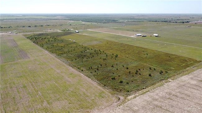 Aerial view of sparsely populated area featuring rows of crops | Image 6