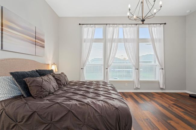 Bedroom with wood finished floors, multiple windows, and a chandelier | Image 16