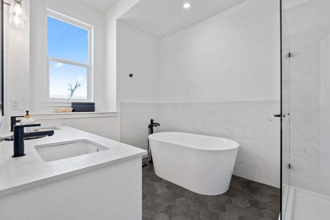 Bathroom featuring a wainscoted wall, recessed lighting, tile walls, a soaking tub, and vanity | Image 19