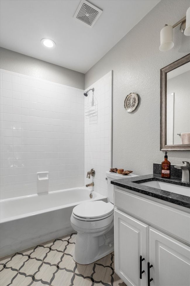 Bathroom featuring vanity, shower combination, and a textured wall | Image 26