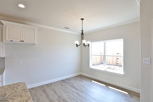 Unfurnished dining area featuring ornamental molding, a chandelier, light wood finished floors, and recessed lighting | Image 12