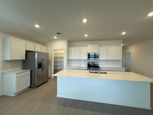 Kitchen with stainless steel appliances, backsplash, a sink, recessed lighting, and lofted ceiling | Image 17