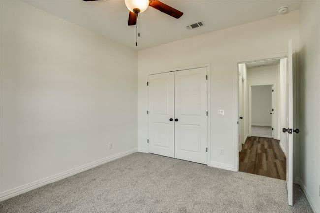 Unfurnished bedroom with carpet flooring, baseboards, visible vents, a closet, and ceiling fan | Image 24
