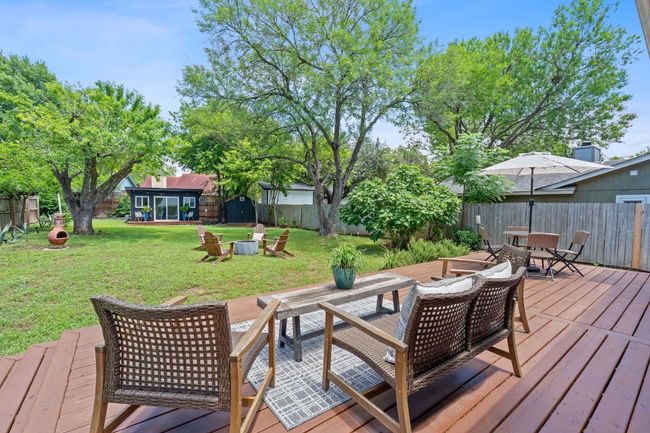 Wooden terrace with outdoor dining area and a fenced backyard | Image 32