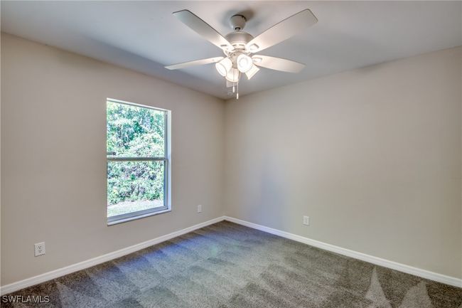 Spare room with a ceiling fan, dark carpet, and baseboards | Image 41