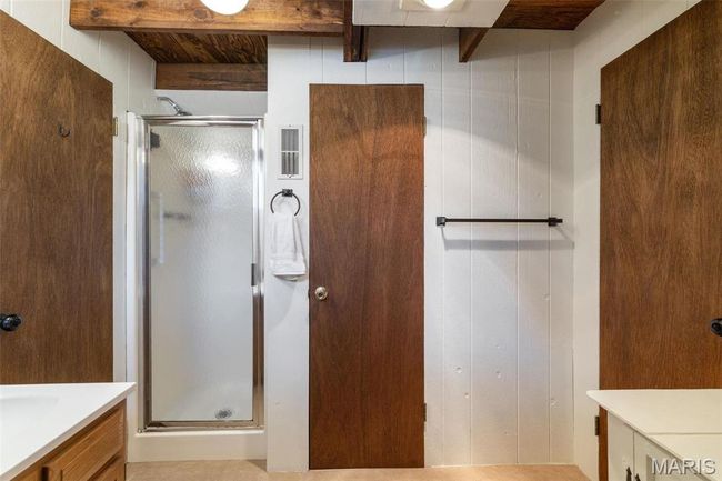 Bathroom featuring vanity, beamed ceiling, visible vents, and a stall shower | Image 24