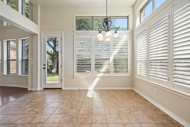 Enjoy your morning coffee in the light-filled breakfast area, where large windows offer serene views of the beautifully treed backyard. | Image 15