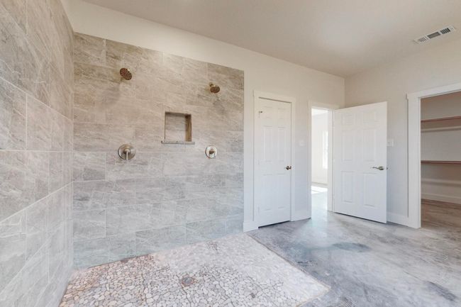 Bathroom with visible vents, a closet, and a tile shower | Image 25