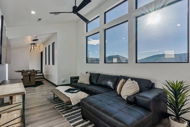 Living area with light wood-style floors, visible vents, baseboards, and a ceiling fan | Image 31