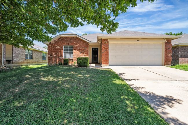 Brick home with driveway, a front yard, a garage, brick siding, and a shingled roof | Image 25