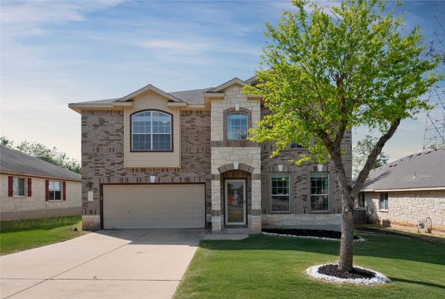French provincial home with concrete driveway, a garage, a front yard, central AC, and stone siding | Image 36