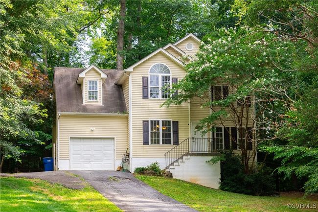 View of front of property featuring asphalt driveway and view of wooded area | Image 28