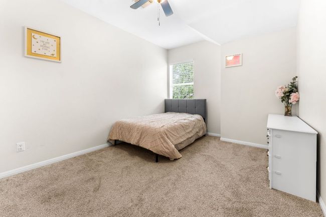Bedroom featuring light carpet, baseboards, and a ceiling fan | Image 23