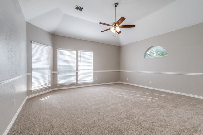 Spare room with carpet flooring, vaulted ceiling, baseboards, visible vents, and ceiling fan | Image 14