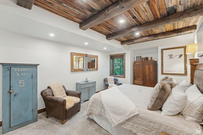 Carpeted bedroom with a wood ceiling with exposed beams and recessed lighting | Image 40