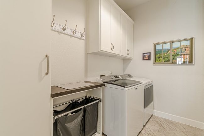 Laundry area with cabinet space, independent washer and dryer, and baseboards | Image 10