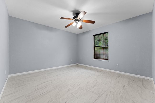 Empty room with ceiling fan and baseboards | Image 22