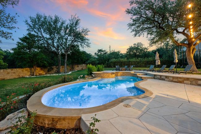 View of pool with a patio area, a lawn, and a pool with connected hot tub | Image 7