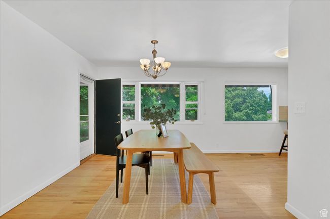 Dining space featuring light wood-style flooring and a chandelier | Image 5